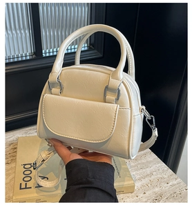 Detail of white shell handbag texture with silver metal hardware and adjustable strap