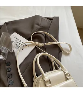 Cream white Boston bag with leather texture and adjustable long shoulder strap