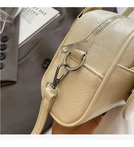 Detail of premium silver-tone hardware and wrinkled leather texture on cream crossbody bag