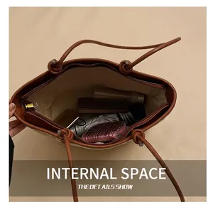 Top view of spacious straw tote interior with umbrella and cosmetics on white fabric