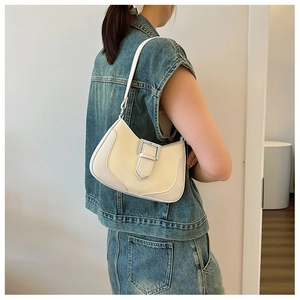 Detail view of a cream white crescent hobo bag with a stylish silver buckle strap