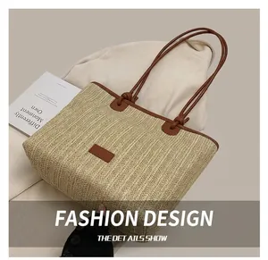 Detail of straw woven texture and brown leather strap on a beige beach tote bag