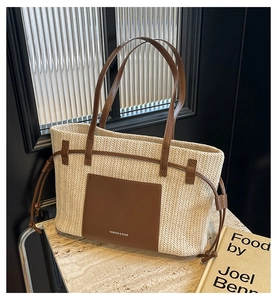 Detail of V-shaped weave pattern and brown leather patch on a large straw tote bag