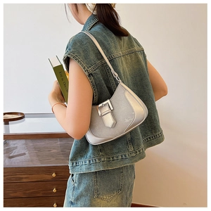 Silver-grey crescent underarm bag with metal buckle shown in a vintage lifestyle setting