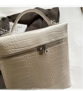 Dettaglio borsa beauty in pelle coccodrillo bianco panna con cerniere argentate
