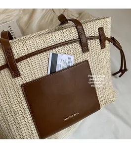 Close-up of woven straw tote bag featuring a leather front pocket for convenient storage
