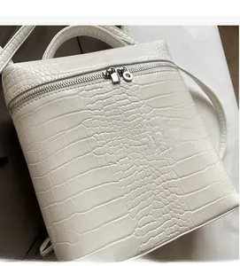 Dettaglio zaino bianco in ecopelle coccodrillo con anello metallico sulla cerniera lampo