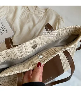 Detail of magnetic metal clasp and herringbone fabric lining inside the woven tote bag