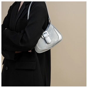 Detail of metallic silver crescent underarm bag styled with a chic black blazer