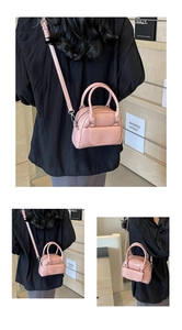 Detail view of a pink mini Boston crossbody bag with dual handles and silver hardware