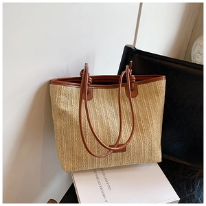 Macro detail of straw tote bag showing woven texture and brown leather shoulder strap