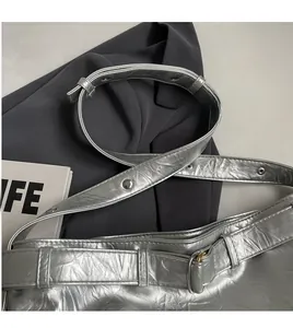 Detail view of silver pleated shoulder bag with smooth adjustable long shoulder strap