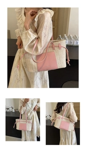 Close-up of woven tote bag with pink leather shoulder straps and front pocket detail