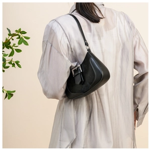 Close-up of black crescent shoulder bag with leather patchwork and silver buckle detail
