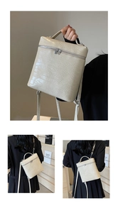 Dettaglio dello zaino quadrato crema con trama coccodrillo e doppie zip metalliche