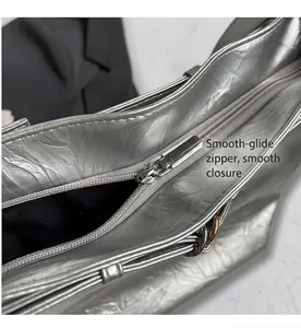 Detail shot of smooth silver zipper on a metallic textured hobo bag with black lining