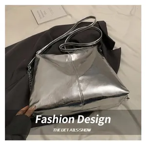 Detail of silver metallic tote bag with faux leather texture and elegant chain strap