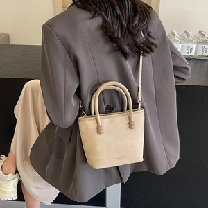 Mini cabas beige en cuir texturé avec détails de perles roses sur la poignée
