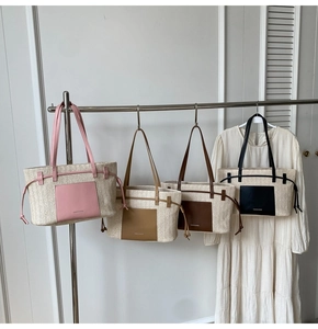Macro detail of multi-colored woven tote bags with leather straps on a display rack