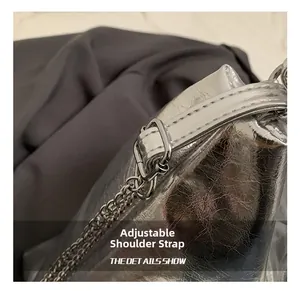 Close-up of adjustable strap and silver metal chain on shiny wrinkled tote bag