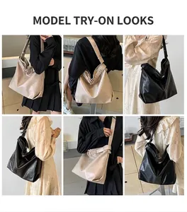 Model wearing a large hobo shoulder bag in black and off-white with smooth leather texture