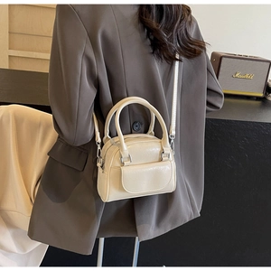 Cremefarbene PU-Leder Handtasche getragen von Model im anthrazitfarbenen Blazer