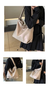 Detail of pearlescent beige hobo bag showing high-gloss wrinkled leather and wide shoulder strap