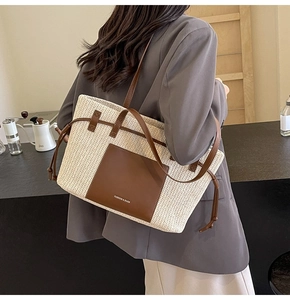 Detail of woven straw tote bag featuring brown leather trim and stylish logo print