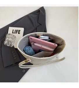 Vista dall'alto dell'interno spazioso della borsa tote in pelle beige con accessori