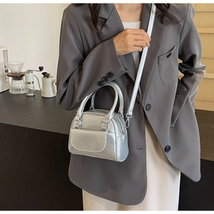 Detail der silbernen Metallic-Handtasche mit Crinkle-Struktur und zwei Griffen im City-Look