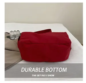 Detail view showing the wear-resistant base of the large red nylon tote bag