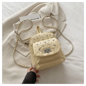 Détail du mini sac à dos crème matelassé avec strass brillants et bandoulières en chaîne