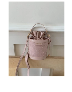 Detail of the pink bucket bag's drawstring closure and durable canvas leather texture