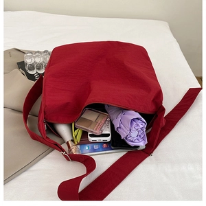 Spacious red crossbody tote bag showing large capacity for phone and cosmetics