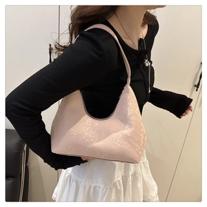 Side view of a pink snakeskin embossed hobo bag worn by a model for daily styling