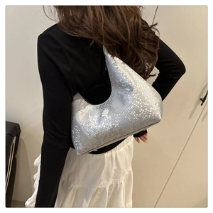Detail of silver snake-textured moon-shaped hobo bag with metallic finish on model