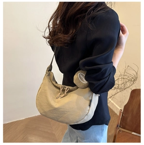 Detail of khaki nylon shoulder bag with drawstring zipper and round coin pouch detail