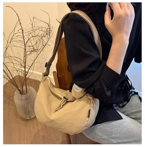 Close-up of khaki nylon tote bag with wide strap shown in an aesthetic indoor setting