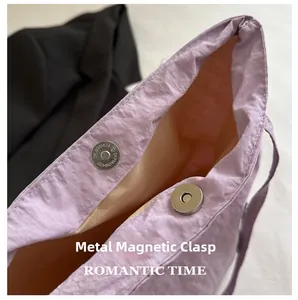 Detail shot of the secure magnetic silver buckle on the light purple fabric bucket bag