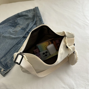 Vue intérieure du sac en toile crème montrant le rangement du mobile et écouteurs