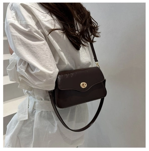 Side view of dark brown glossy leather crossbody bag with golden metal lock detail