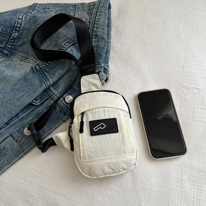 Detail of white nylon chest bag with black adjustable strap and logo on grid background