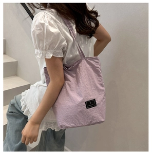 Detail of light purple textured nylon tote bag with black Fanvissa logo patch