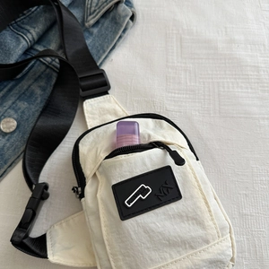 Detail of white nylon crossbody bag with zipper pocket and capacity display
