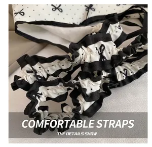 Close-up of sweet ruffled shoulder strap with black polka dots and bow print detail