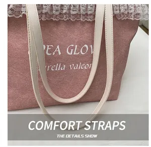 Detailed close-up of pink suede tote bag with white lace trim and reinforced straps