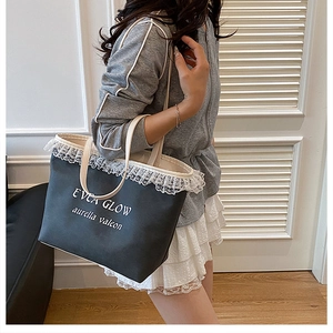 Détail du sac cabas en toile noir avec dentelle blanche et logo EVEA GLOW
