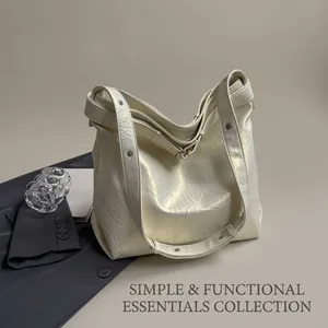 Detail of cream large tote bag featuring pleated pearl texture and metallic rivets