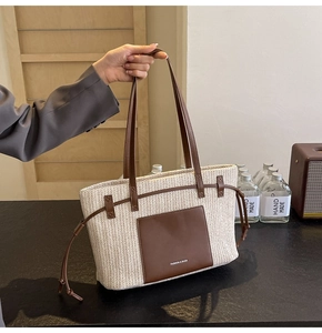 Detail of hand-woven tote bag showing the textured V-pattern and brown leather pocket