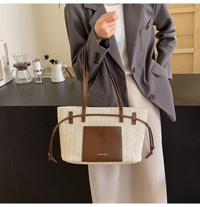 Detail of woven straw tote bag with V-shaped texture and brown leather pocket and straps